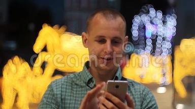 在城市的夜晚，人们使用智能手机上的应用程序短信。 英俊的年轻商人用智能手机微笑快乐